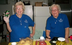 Sisters of Providence Lucy Nolan, left, and Mary Frances Keusal, right, volunteer preparing and serving food for shoppers and helpers at the October rummage sale for Providence Family Services in Chicago.