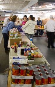 After distributing food to the family, Providence Food Pantry volunteer Diana Bird plays with baby Alise Parker, held by her mother Brandy Smith of West Terre Haute.