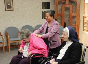 Sister Su-Hsin Huang, standing, gives a back massage to Sister Rita Lerner as she and Sister Rosalie Marie Weller, right, prepare to say their daily rosary in the Chapel at Providence Health Care.