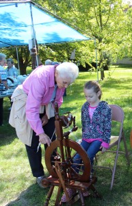 Sister Jeanne Knoerle gives a fiber spinning lesson to this young girl at a White Violet Farm Alpacas open house.