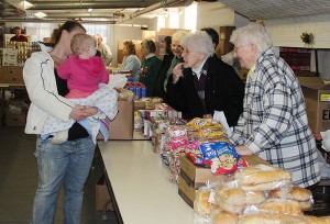 Sister Mary Pat Peacock, at right, and Sister Florence Norton play with a baby as they pass out food at Providence Food Pantry in West Terre Haute in 2012.