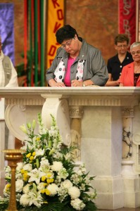 Sister Deborah Campbell signs her name, adding hers to the book that contains the names of thousands of Sisters of Providence who have gone before her, during her perpetual vows ceremony June 30 in the Church of the Immaculate Conception at Saint Mary-of-the-Woods.