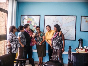 Sister Deborah, third from left, sports her gifted scarf and writes down the names of the CRS office staff in Nairobi for whom she promises to pray. 
