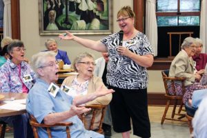 Providence Associate Jane Fischer leads sisters in song during a social for Sisters of Providence and Providence Associates.