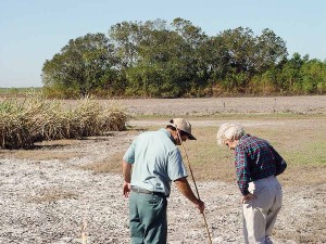 Sister Helen surveys a field damaged by a hurricane with the farmer.