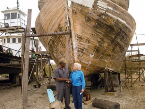 Sister Helen Vinton, right, speaks with fisherman Douglas Wells in front of his boat. Sister Helen created a fisher loan program, helping Douglas and others repair boats damaged by hurricanes.