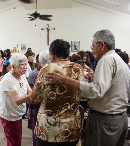 Providence in the Desert's Sister Carol Nolan becomes a part of the community in the rural southern California towns where she lives and serves. Here she greets a couple at Mass at the mission location in Thermal, California, where the largely immigrant population gathers for weekly Mass in a community center because there is no church available.