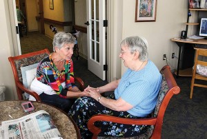 Deanna Ruston spends time visiting and praying with Sister Suzanne Buthod during a volunteer week at the Woods. 