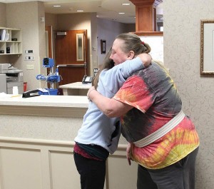 On a return visit for outpatient therapy, Lorre Thompson, above right, greets staff members she became close to at Providence Health Care during a several-week rehabilitation stay.