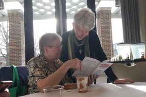 Sister Donna Butler (seated) and Sister Marsha Speth look over the schedule for the 2016 Indiana State University Human Rights Day.