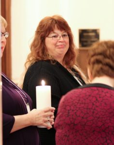 Donna Snelling carries a candle prepares to carry a candle in the procession at her first commitment liturgy as a Providence Associate in 2014.