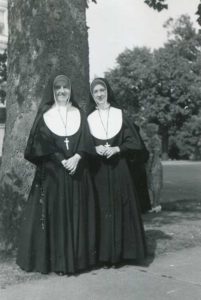 This photo is of Sister Sheila (left) and Sister Rose Celeste Michaels. It was taken either in 1936 or 1937 on the southwest side of Foley Hall by the big Sycamore tree on the circle.