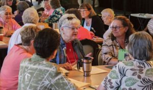 Article author Sister Rosemary Nudd, center, in conversation with sisters and associates at her table on the first day of Chapter, including Providence Associate Teresa Clark at right.