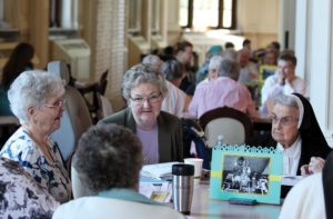 From left, Sisters Marikay Duffy, Therese Guerin Sullivan, and Helen Therese Conway participate in conversation at their table.
