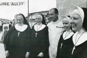 This undated photo shows (from left) Sister Ann Clouser (RIP), Sister Eleanor Bussing (RIP), Sister Amata Dugan (RIP) and Sister Paul Marie Gutgsell (RIP) with Indy 500 driver Parnelli Jones.