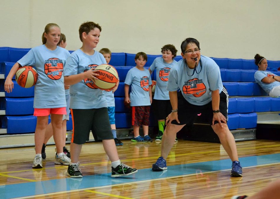 a sister playing basketball with grade school kids