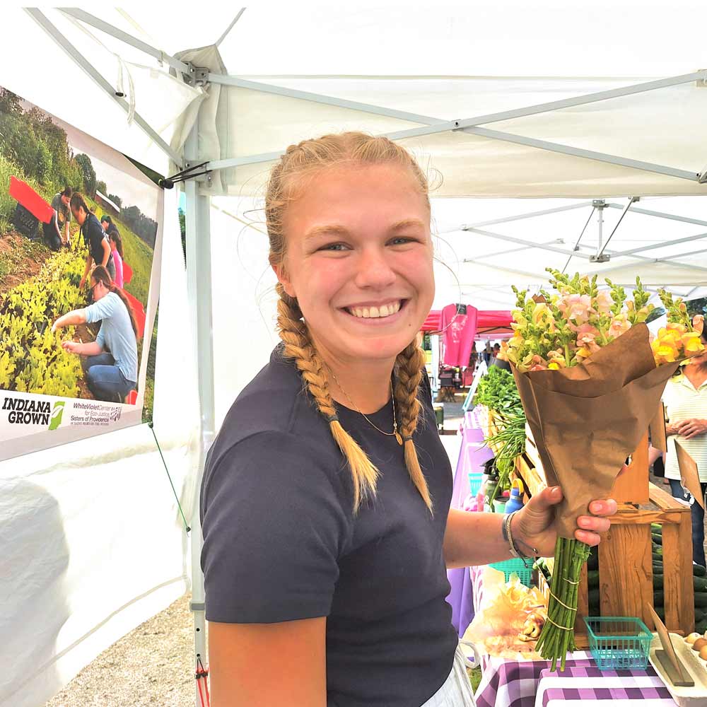WVC Intern, holds a freshly harvested bunch of flowers.