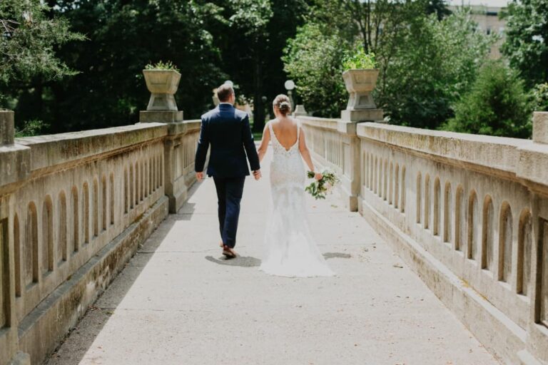 A bride & groom walking on the historic stone bridge at the Woods.