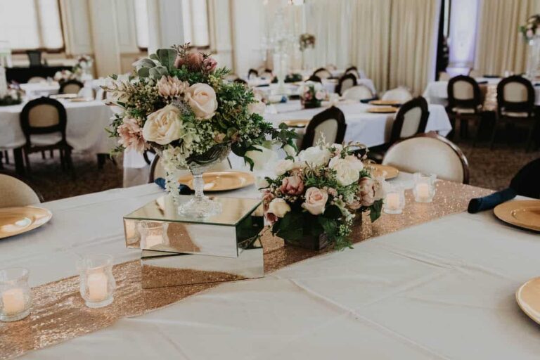 Decorative flowers and places settings on a table with a white tablecloth