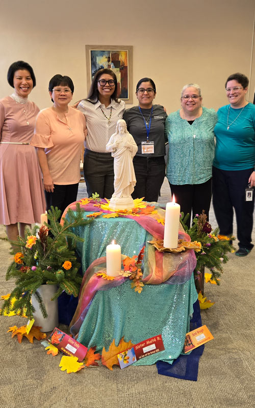 group of smiling women next to lit candles