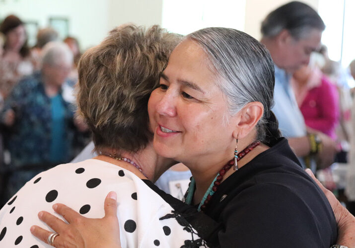 Sister Joni Luna (right) embracing a guest.