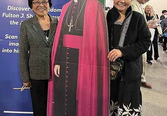 Sister Editha (left) with Dr. Lily de La Cruz next to a cutout of the late Archbishop Fulton J. Sheen.
