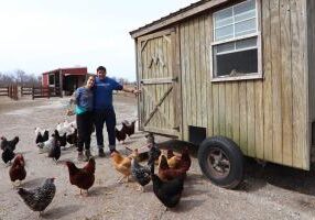Students from Creighton University who attended the 2019 Alternative Spring Break pose with chickens at White Violet Center for Eco-Justice.