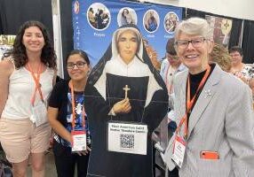 (From left) Sarah Knoblock, Sister Stephanie Rivas and Sister Mary Montgomery with a cutout of Saint Mother Theodore Guerin.