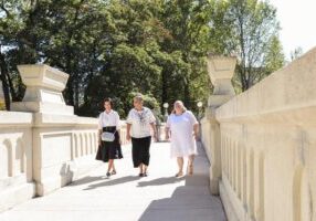 Sisters of Providence Director of Vocations Sister Joni Luna walks with Ann and Matié to their entrance ritual. 