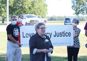 Sister Paula Damiano speaks to media during a press conference prior to the initial execution date of Daniel Lewis Lee. Holding the Congregation's Love Mercy Justice sign are Arthur Feinsod and Sister Jeanne Hagelskamp while Karen Burkhart stands behind.