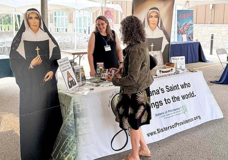 Amy speaking with a visitor at the booth.