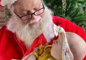 At Christmas Fun at the Woods, the Christ who comes in a red Santa suit and cradles an infant.