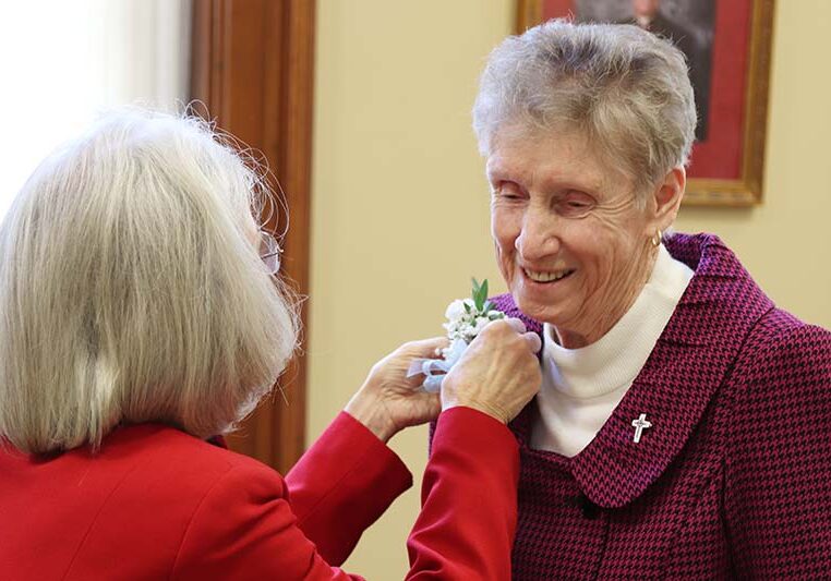 Vicar/General Treasurer Sister Jeanne Hagelskamp (left) pinning a corsage on Sister Claire Hanson.