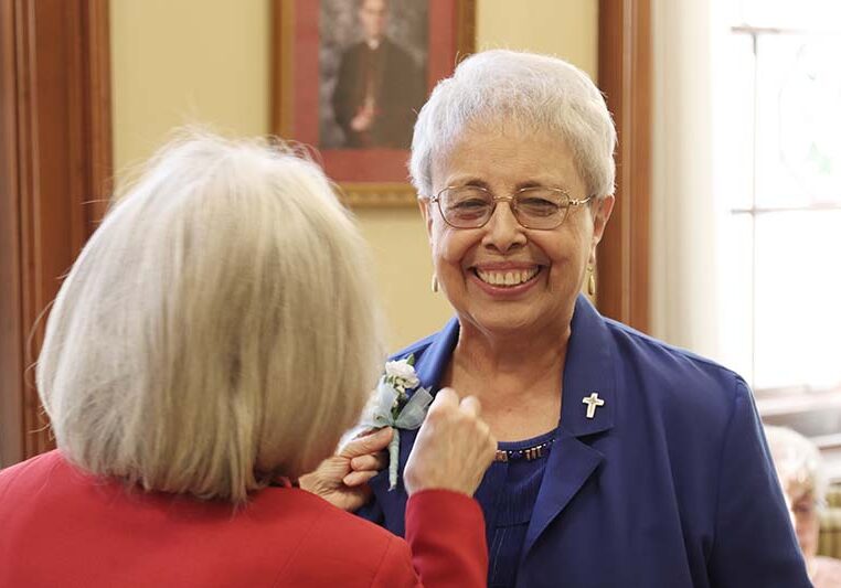 Vicar/General Treasurer Sister Jeanne Hagelskamp (left) pins a corsage on Sister Martha Rojo.