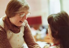 Sister Patty works with a child in 1984.