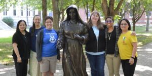Young sisters with the statue of Saint Mother Theodore