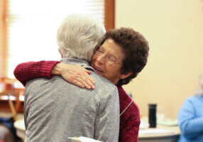 Providence Associate Yvonne Conniff greets a sister with a hug.